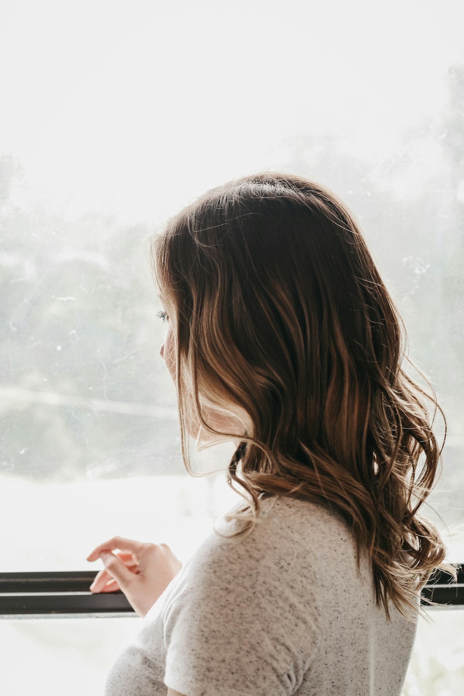 Woman checking her skin tone in natural window light